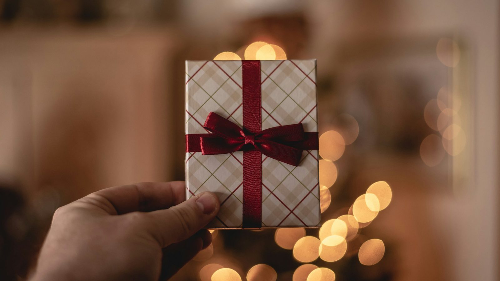 Hand hält eine kleine Geschenkkarte mit Schleife, wie ein Casino Bonus ohne Einzahlung