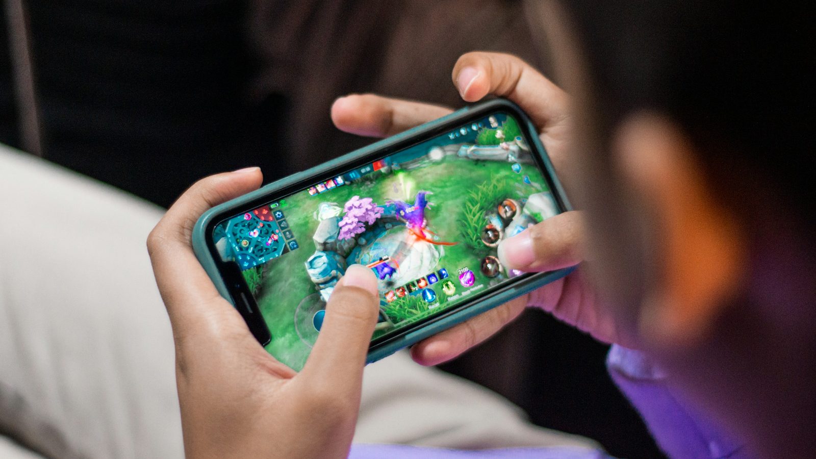 Zwei Hände spielen quer auf dem Smartphone, so fühlt sich ein Handy Casino an