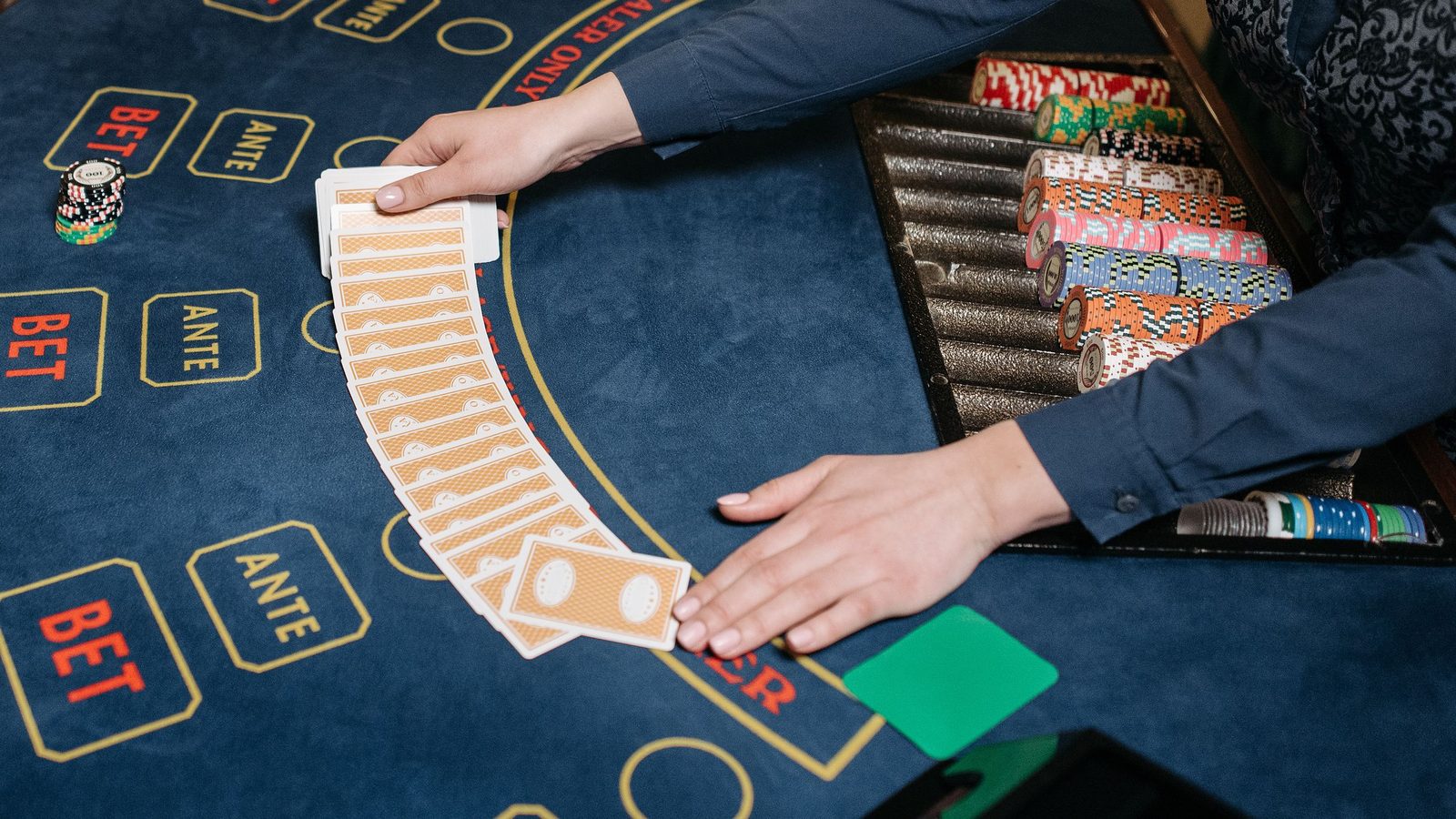 Croupier breitet die Karten am Spieltisch aus, so läuft eine Runde im Live Casino